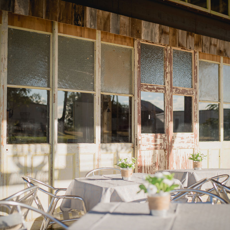 Outdoor dining area with white tablecloths and flowers